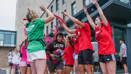 student running through tunnel of Orientation Leaders at check-in
