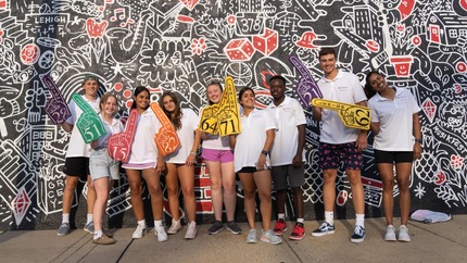 student orientation leaders standing in front of wall